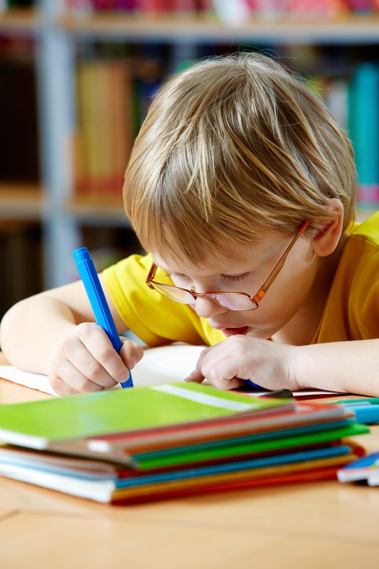 Criança estudando e escrevendo no caderno